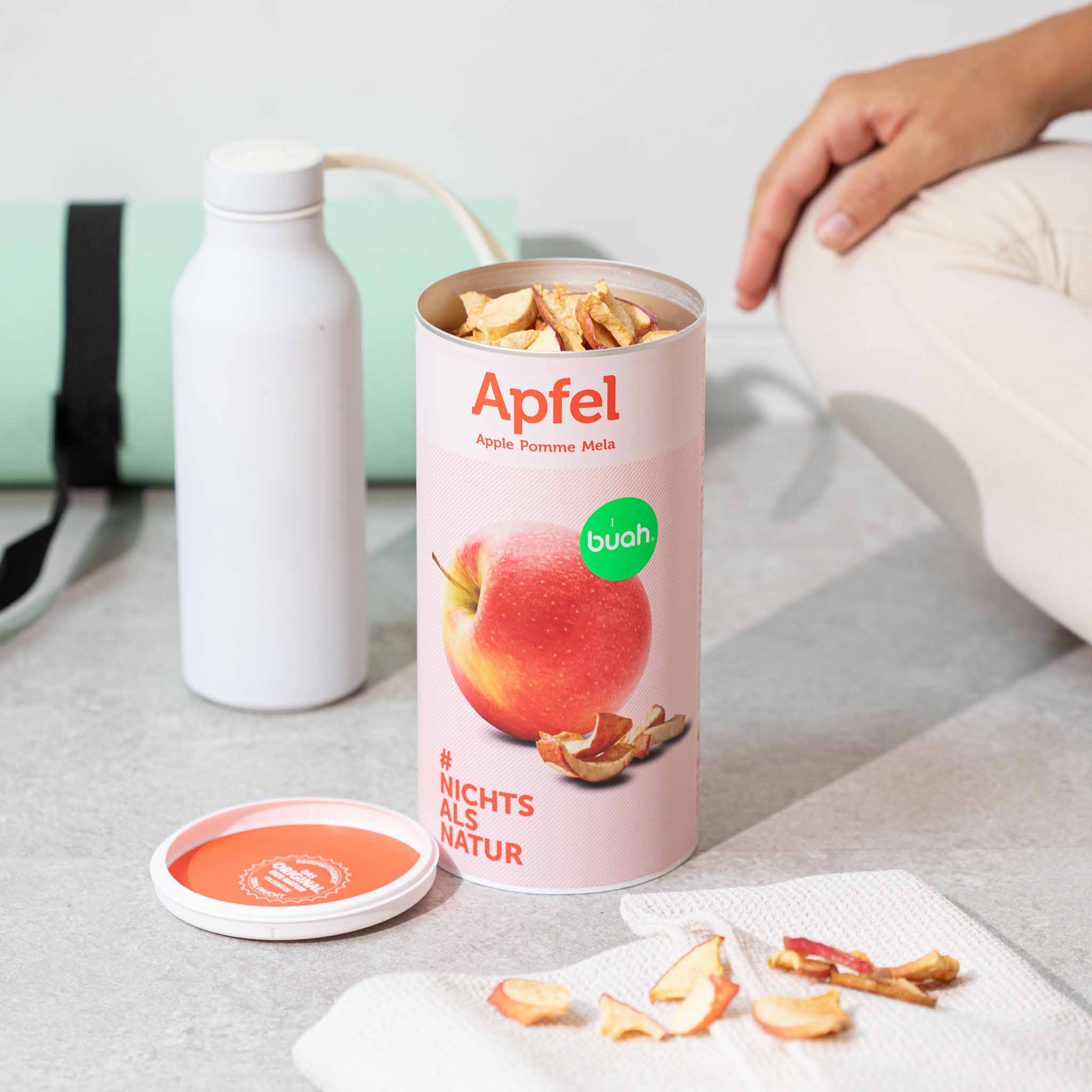 buah grosse Dose Apfel steht auf Boden neben Sportgeraeten