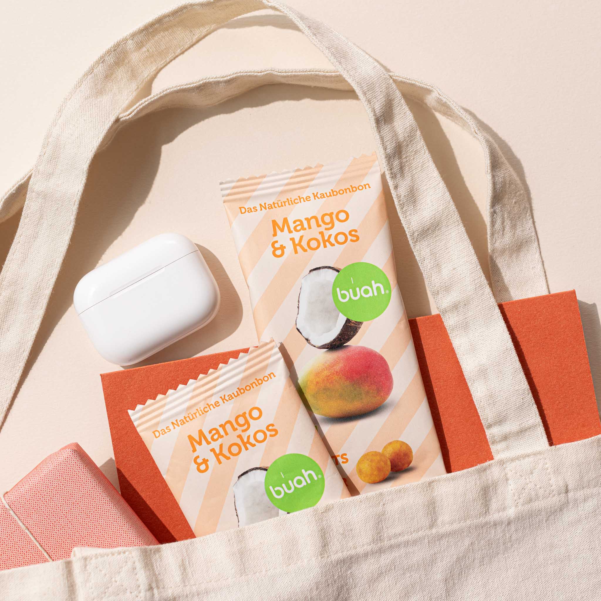 Mango-Kokos Kaubonbon Verpackung von buah ragt neben Notizheft aus Tasche heraus