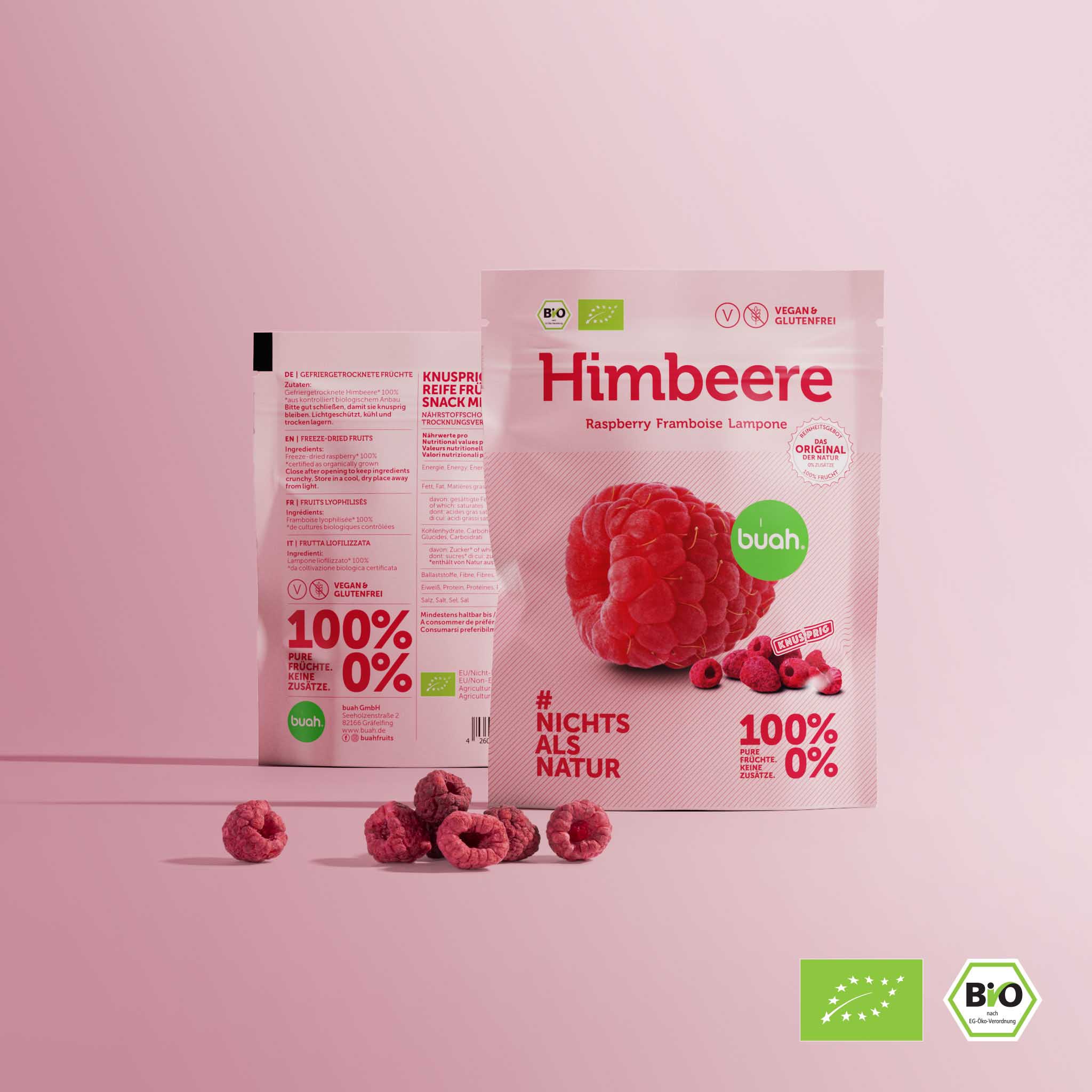 Due confezioni di snack buah stanno una accanto all'altra con lamponi liofilizzati su uno sfondo rosa
