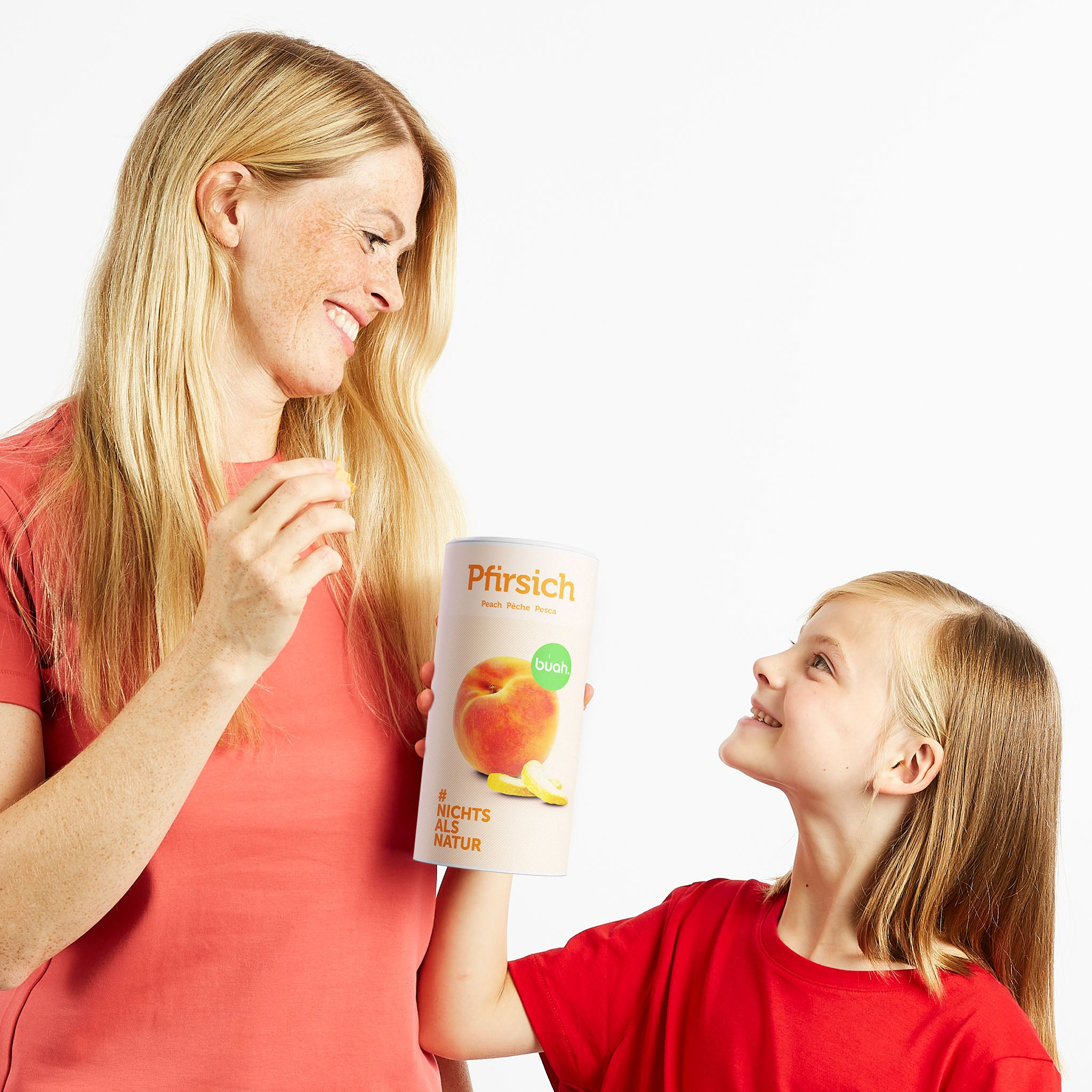 Mamma e figlia si guardano e tengono in mano una lattina di buah pesca liofilizzata