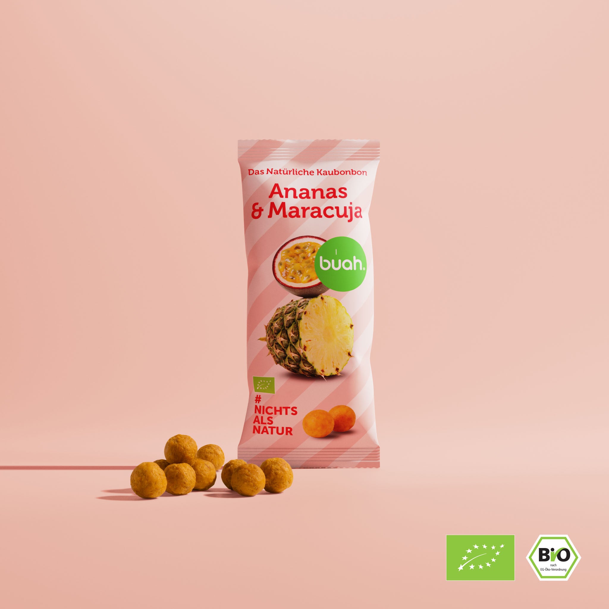 buah Ananas-Maracuja Kaubonbons vor rosa Hintergrund