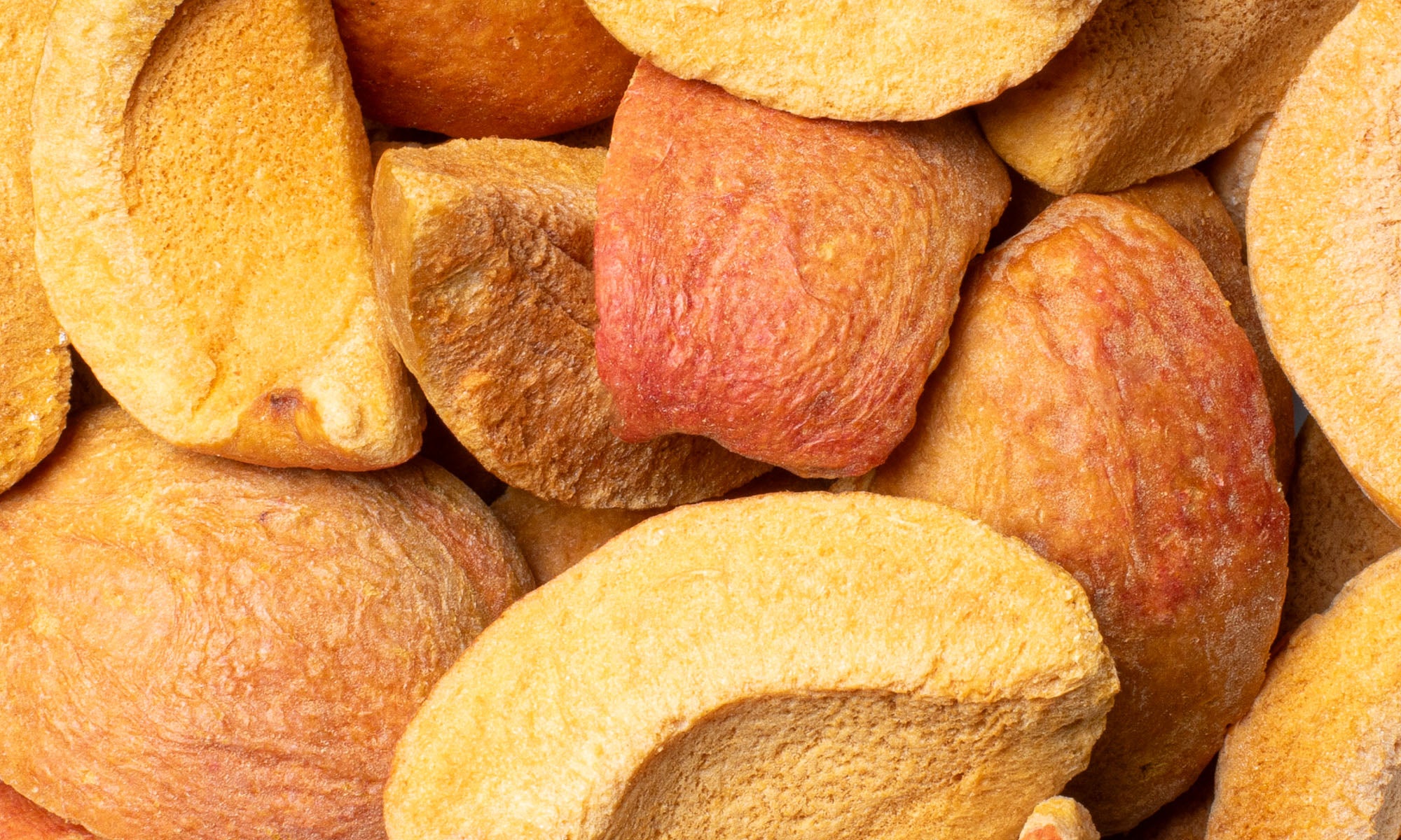 Bild vieler gefriergetrockneter Aprikosen Schnitze in reifer orangener Farbe auf und nebeneinander