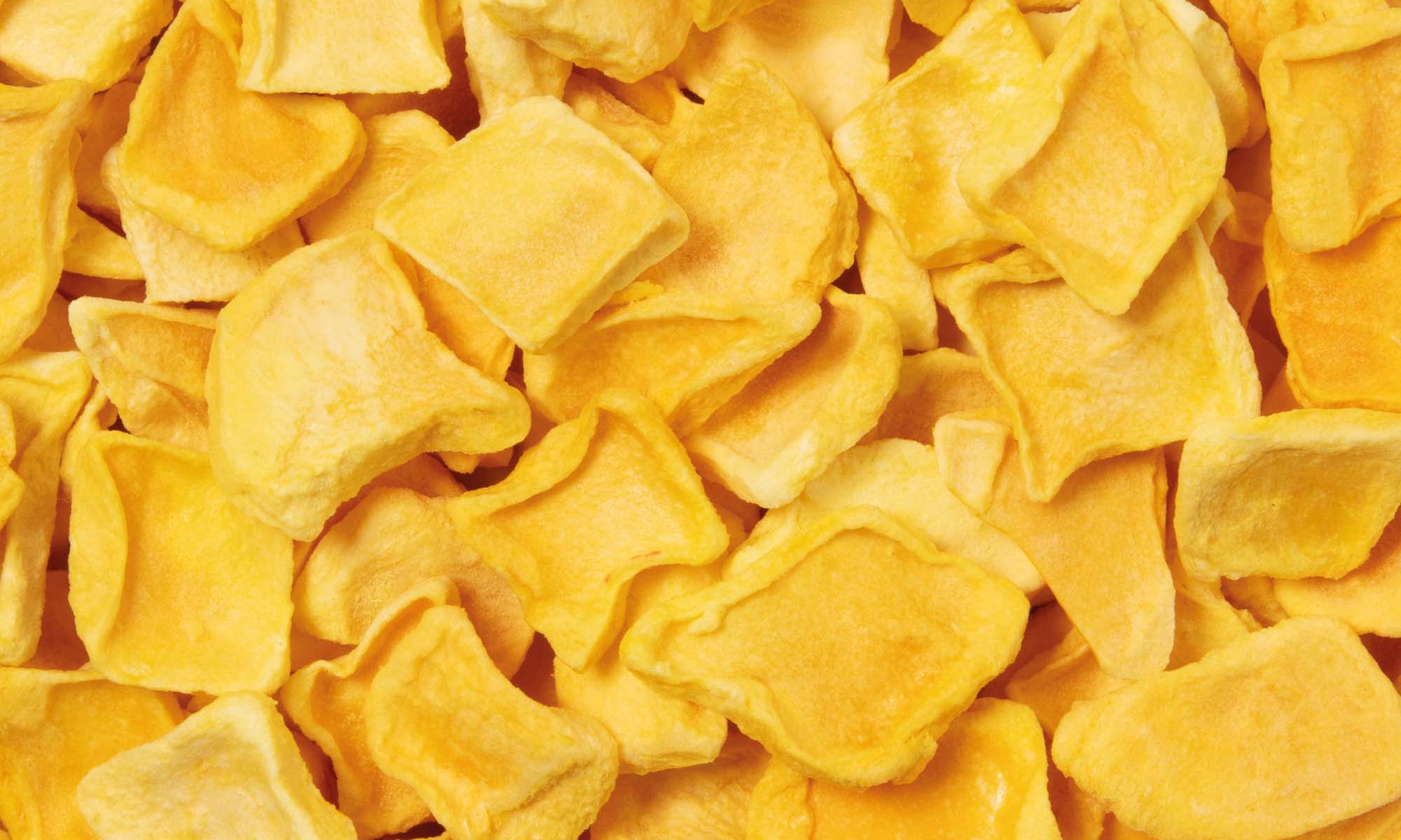 Viele gelbe buah gefriergetrocknete Mango Stuecke liegen neben und aufeinander