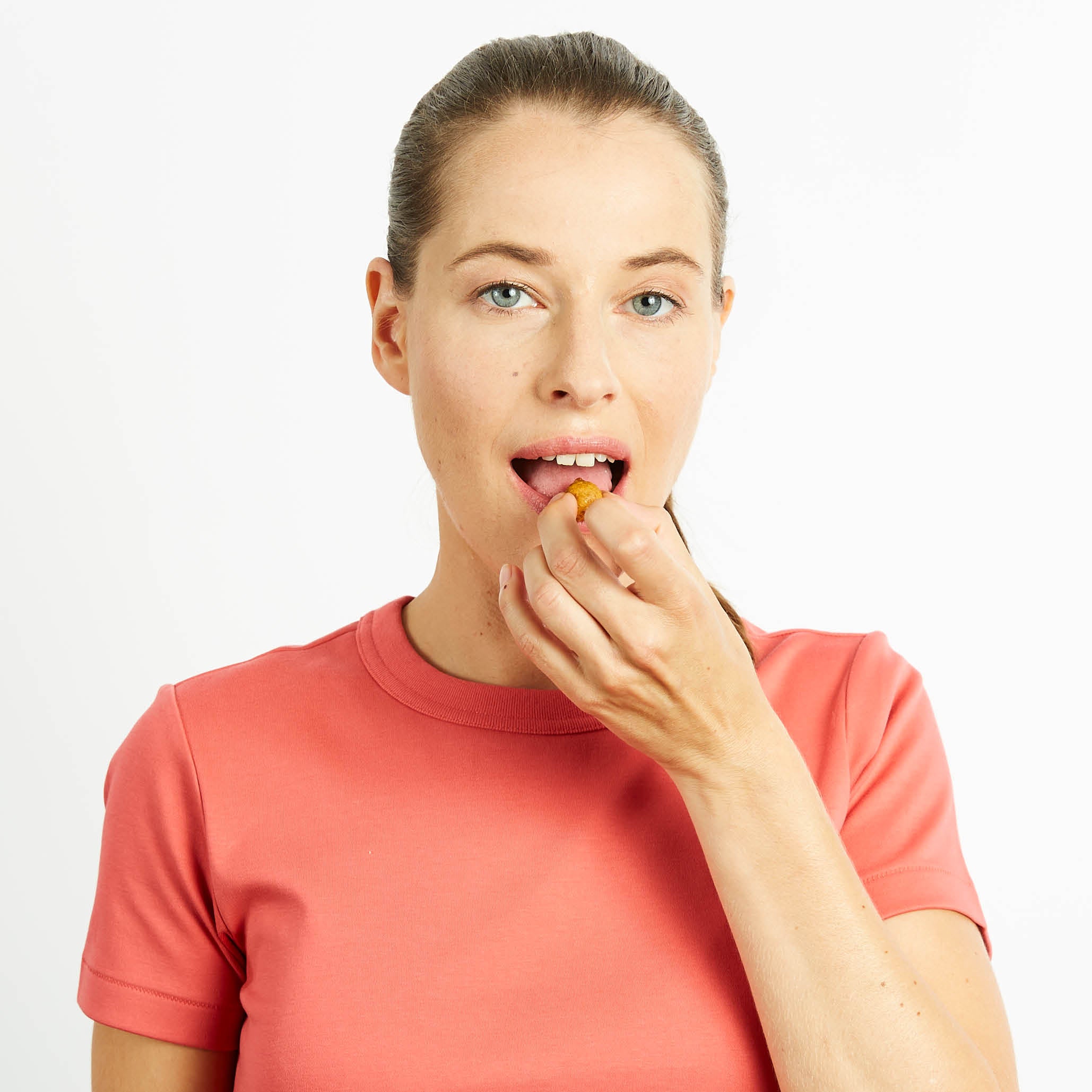 Zufriedene, junge Frau snackt buah Ananas-Maracuja Kaubonbon