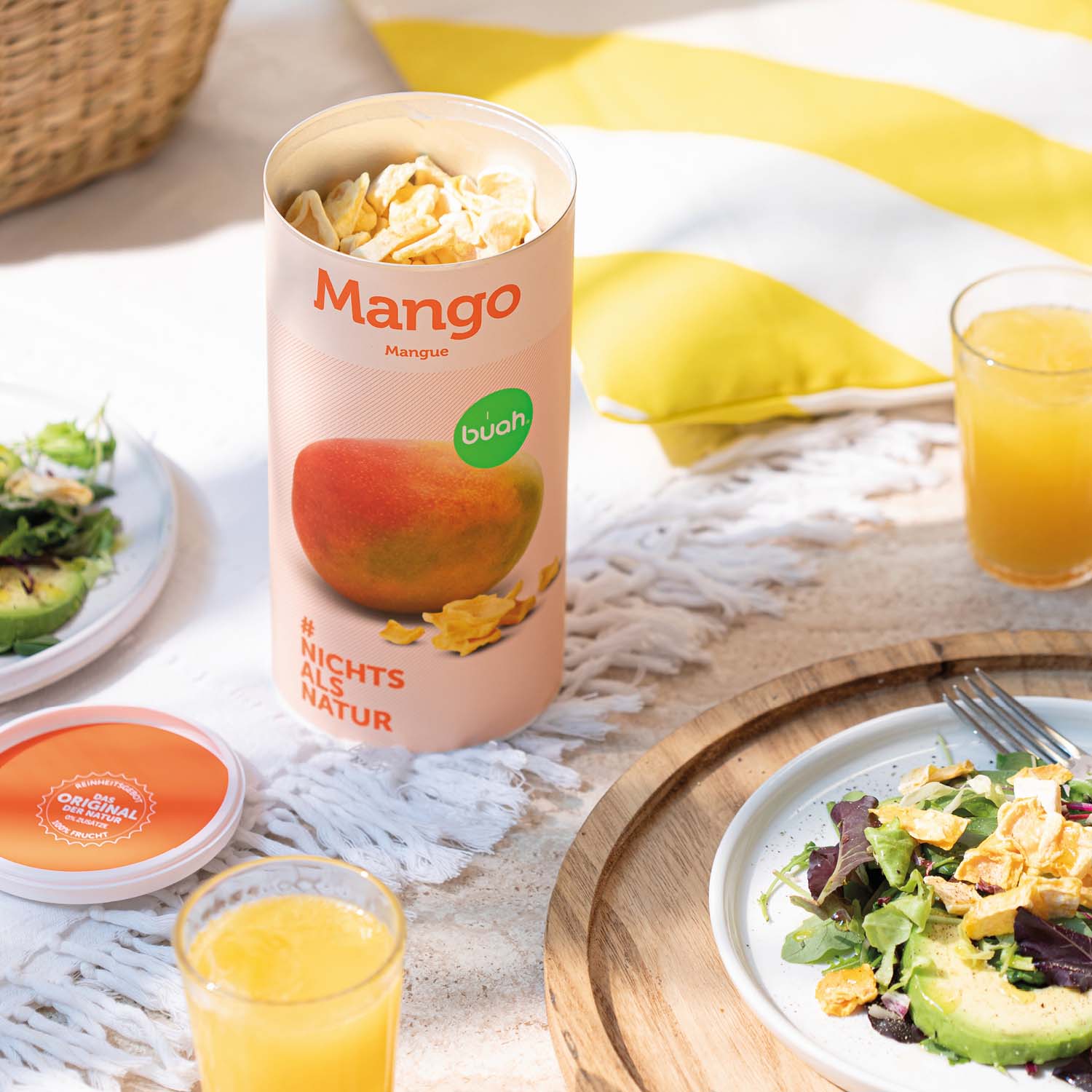 Dose buah gefriergetrocknete Mango auf einer Picknickdecke 