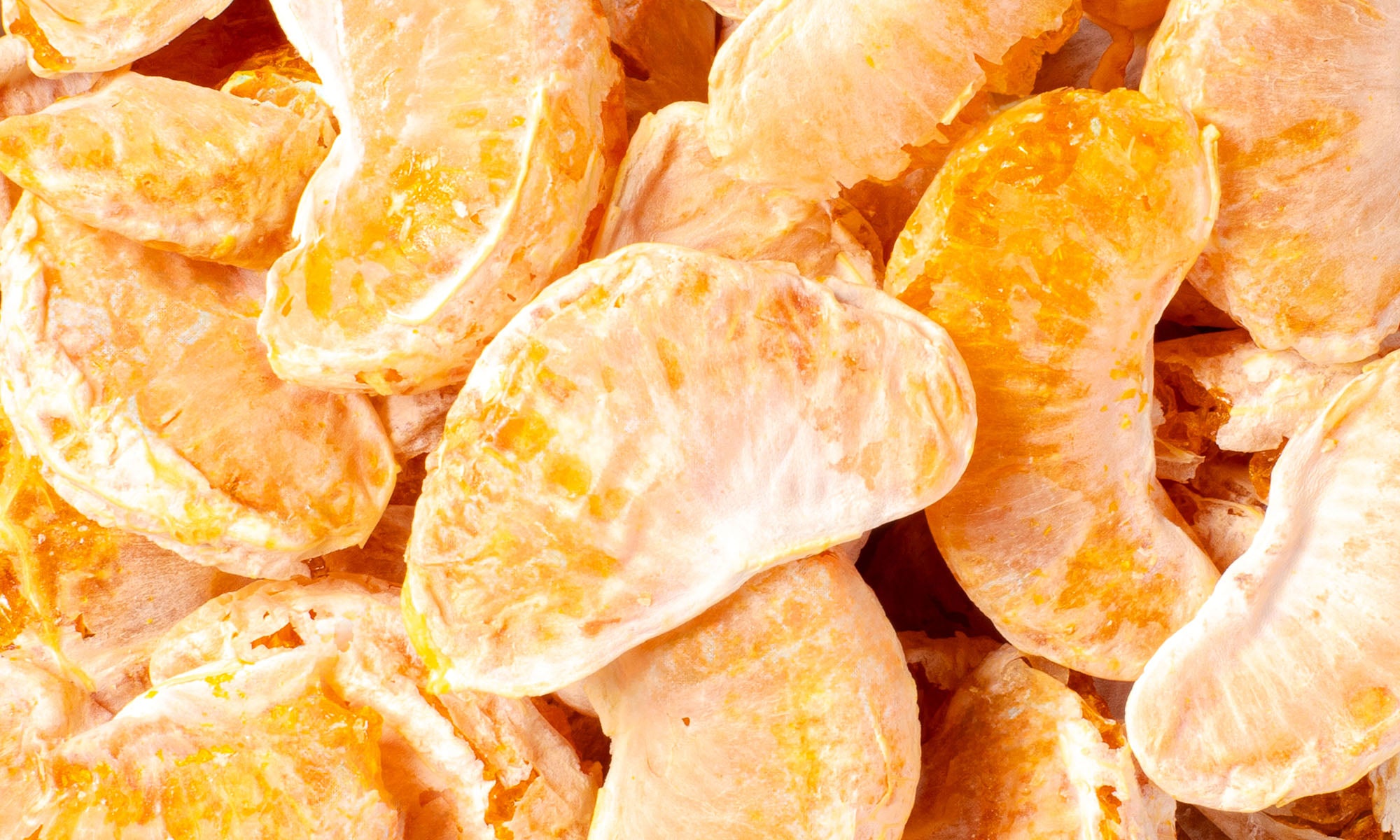 Nahaufnahme vieler getrockneter Mandarinen Schnitze nebeneinander und aufeinander