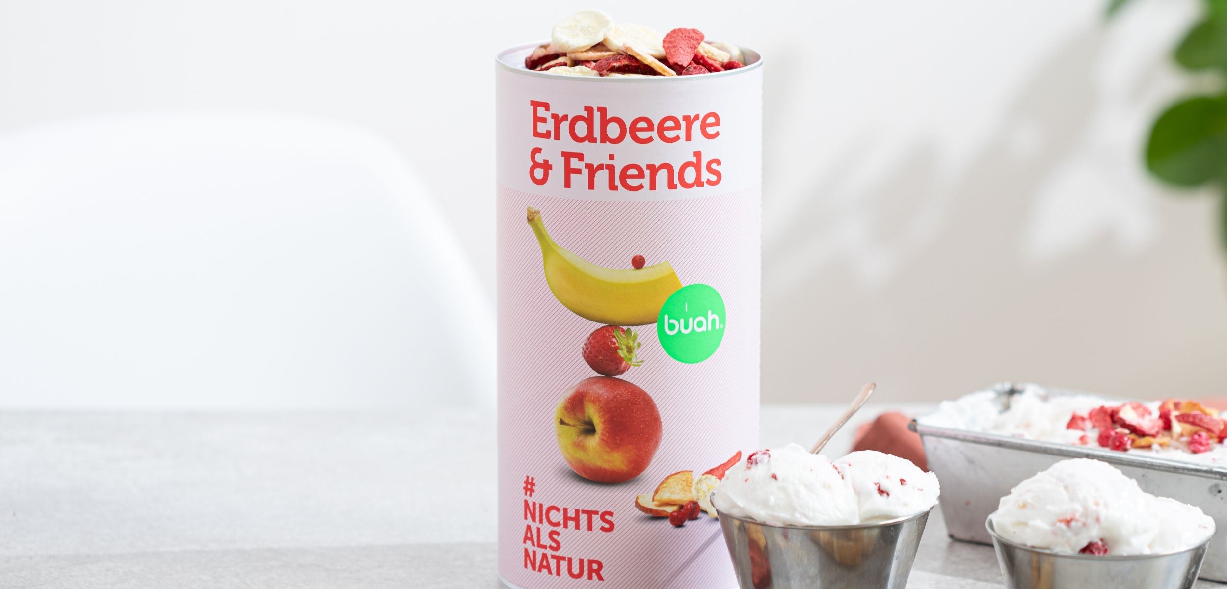 buah Dose Erdbeere & Friends neben zwei Eisbechern, die mit Erdbeere & Friends dekoriert sind