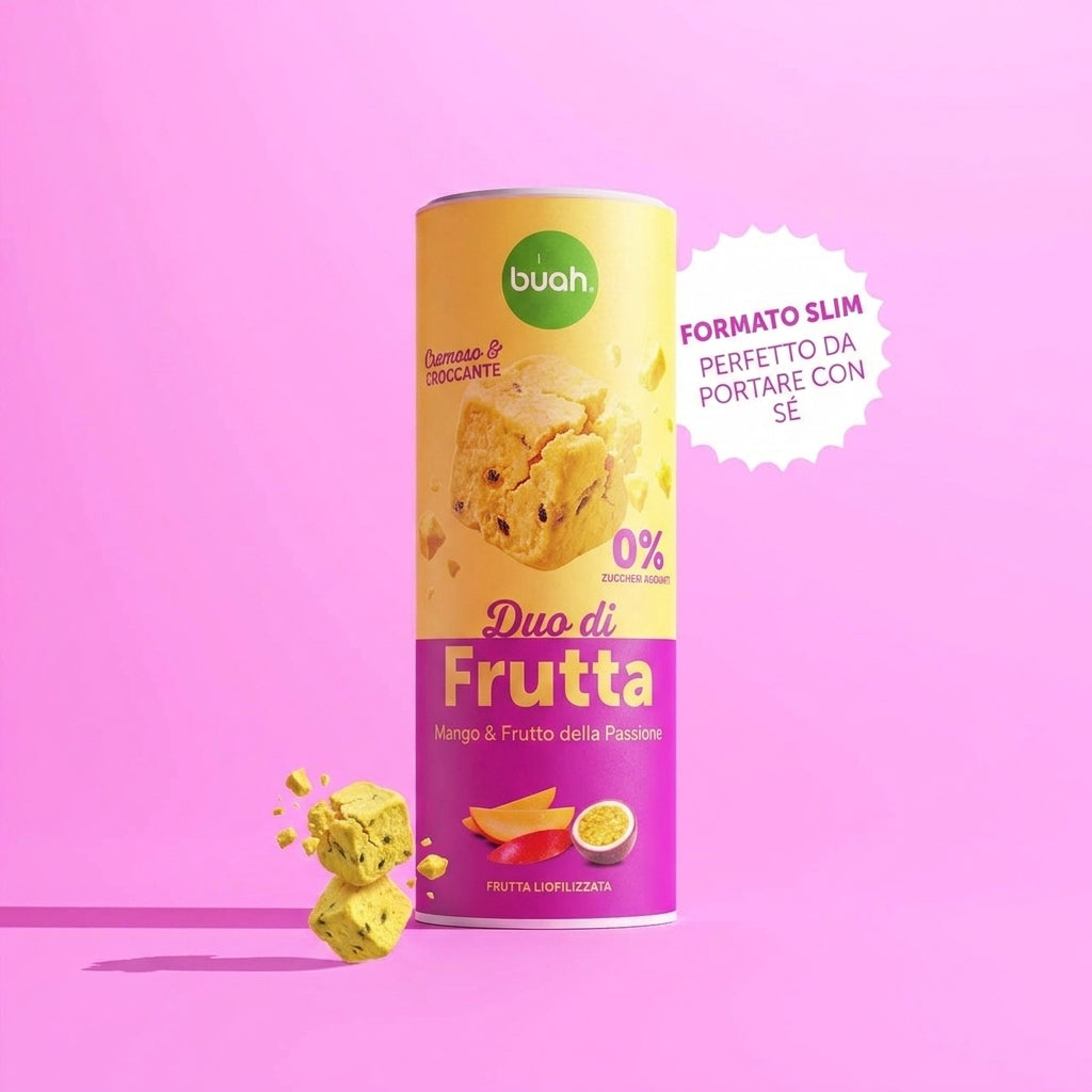 Un barattolo Slim di buah Fruit DUOS Mango & Maracuja si trova al centro davanti a uno sfondo rosa. Accanto si trova un fumetto bianco a zig zag con la scritta "BARATTOLO SLIM PERFETTO DA PORTARE CON SÉ". A sinistra fluttuano cubetti di frutta.