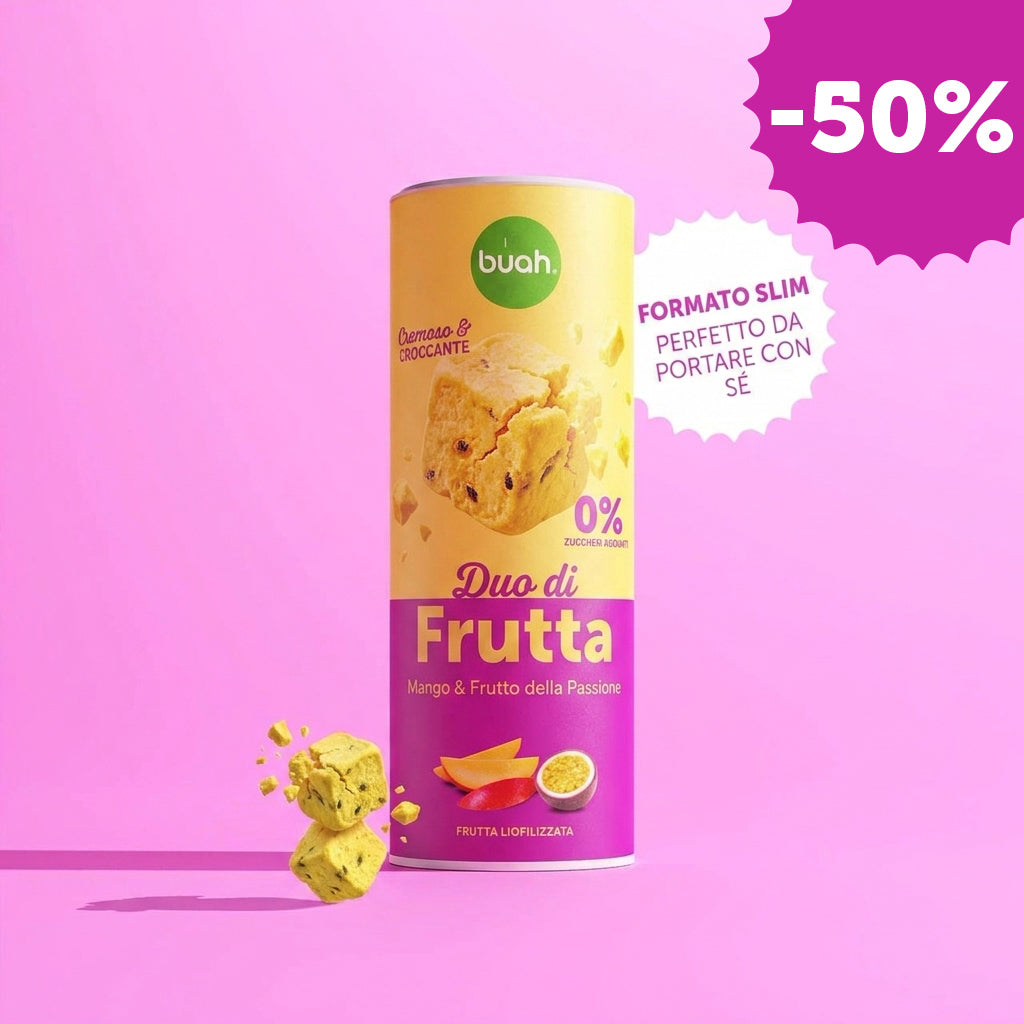 Un barattolo Slim di buah Fruit DUOS Mango & Maracuja si trova al centro davanti a uno sfondo rosa. Accanto si trova un fumetto bianco a zig zag con la scritta "BARATTOLO SLIM PERFETTO DA PORTARE CON SÉ". A sinistra fluttuano cubetti di frutta.