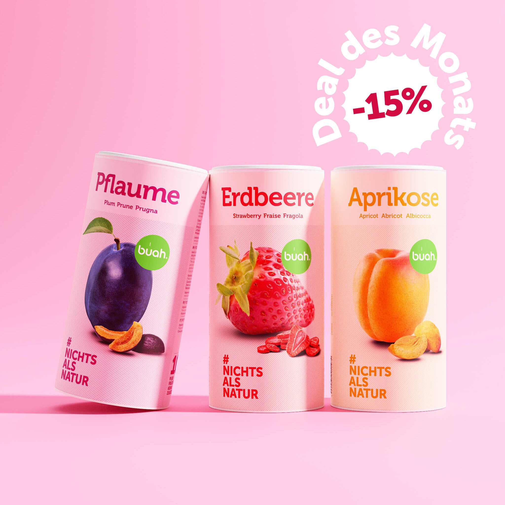buah Set bestehend aus buah gefriergetrockneter Pflaume, Erdbeere und Aprikose, Zylinder foermige Dosen stehen nebeneinander vor rosa Hintergrund - New Year Deal