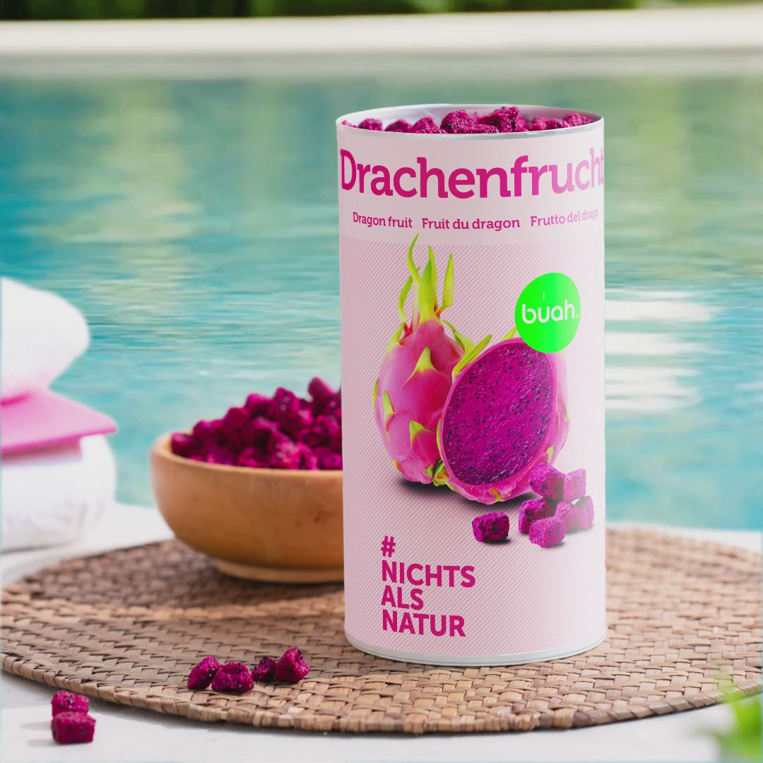Video einer Dose buah Drachenfrucht die am Pool steht, eine Hand nimmt ein Stueck pinke Drachenfrucht von buah aus einer Holz Schale